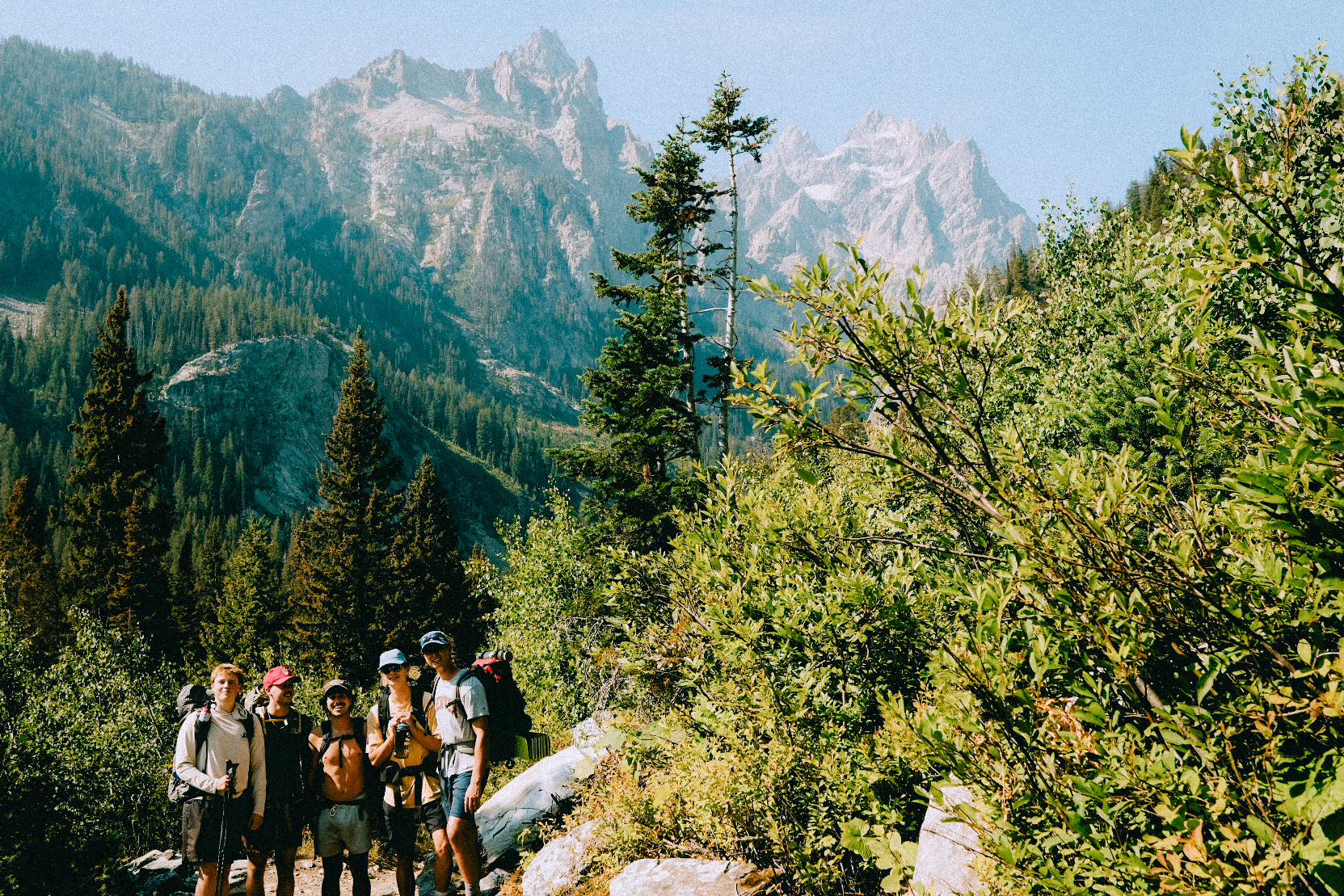 Santo with friends hiking through the Teton mountains on a sunny day